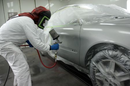 Technician painting a car